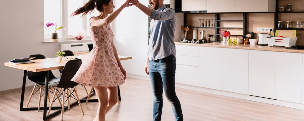 Happy young couple dancing at home in the modern living, Best weekend activities for lovers